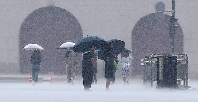 장맛비가 내리는 2일 서울 광화문광장에서 우산 쓴 시민들이 발걸음을 재촉하고 있다.   뉴스1