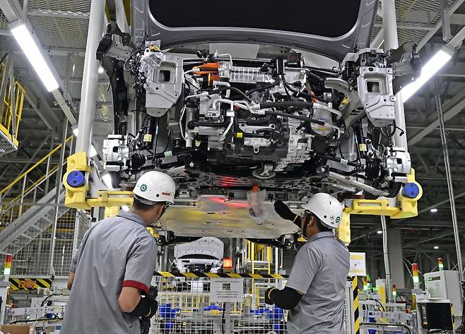 3일 인도네시아 브카시의 현대자동차 생산공장(HMMI)에서 현지 근로자들이 소형 전기 스포츠유틸리티차량(SUV) ‘코나 일렉트릭’ 하부에 HLI그린파워에서 생산한 배터리를 장착하고 있다. 현대자동차 제공