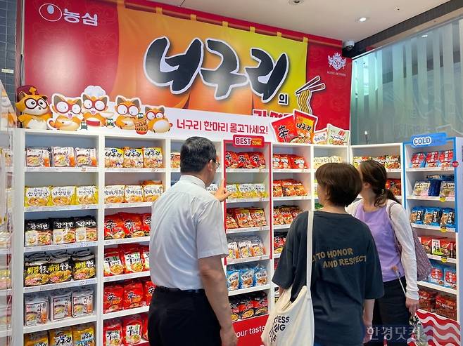 농심 라면 브랜드 진열대 앞에서 라면을 고르고 있는 외국인 관광객들. 사진=김세린 기자