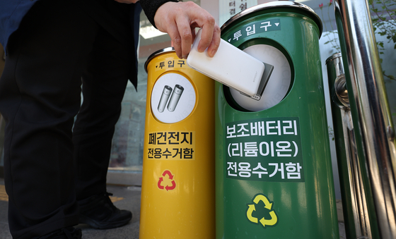 A passerby throws out a lithium-ion power bank at its dedicated recycling bin installed at the Daemyung 9-dong Administration & Welfare Center in Nam District in Daegu on Wednesday. [YONHAP]