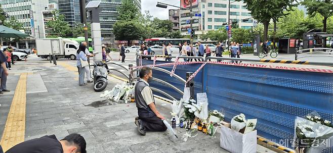 3일 오전 역주행 사고가 발생한 시청역 인근 교차로 인도에서 한 시민이 무릎을 꿇은채 희생자의 넋을 기리고 있다. 김용재 기자
