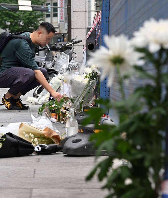 지난 1일 밤 승용차가 인도로 돌진해 9명이 사망하는 사고가 발생한 가운데 3일 오전 서울 중구 서울시청 인근 교차로 사고현장에서 한 시민이 희생자를 추모하며 헌화를 하고 있다. 이상섭 기자