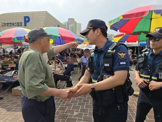 경기남부경찰청 기동순찰2대 4팀 고동수(37·왼쪽에서 두 번째) 경장이 지난 4일 성남 모란시장에서 폭행 피해를 당했다는 시민과 악수하며 사정을 듣고 있다. 손성배 기자