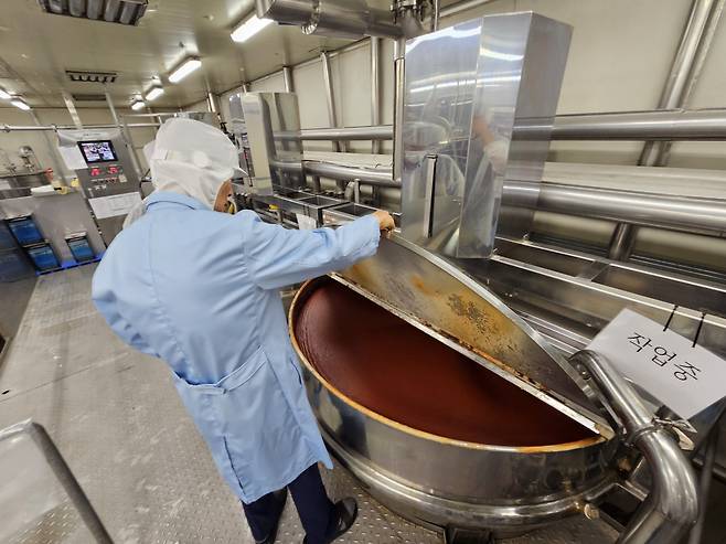 Woomtree's founder and CEO Kim Woo-taek examines the fermenting process of gochujang sauce at the firm's factory in Pocheon, Gyeonggi Province, on Thursday. (Kim Hae-yeon/ The Korea Herald)