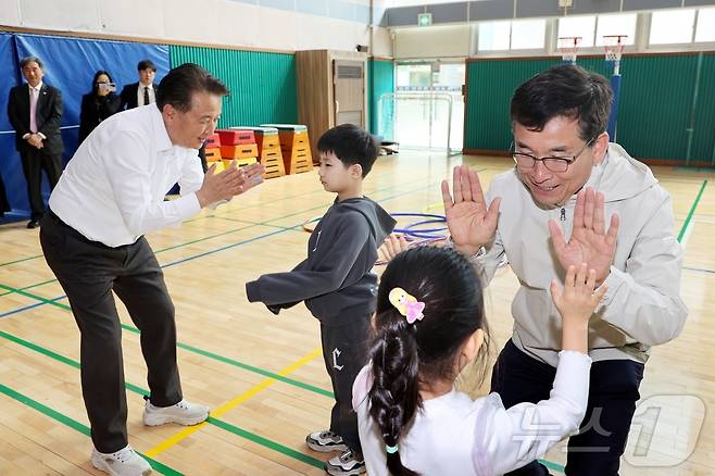 윤건영 충북교육감(오른쪽)과 김영환 충북지사가 지난 3월 15일 청주 샛별초등학교를 찾아 늘봄학교 프로그램에 참여한 학생들을 격려하고 있다./뉴스1