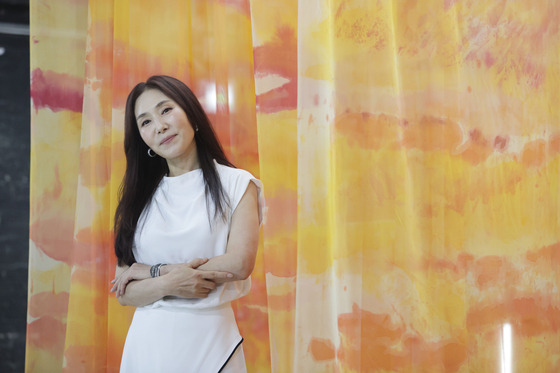 Singer Jang Hye-jin in front of her work at the ″bbuck on & off″ art exhibition in Itaewon, central Seoul [ARTVERSE]