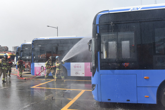 Firefighters spray water on an electric bus during a fire drill in an undated photo provided by the Seoul city government on Monday. [SEOUL METROPOLITAN GOVERNMENT]