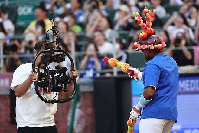 탕후루 헬멧을 쓴 로니 도슨이 탕후루 꼬치를 들고 흥겹게 춤을 추고 있다. 연합뉴스