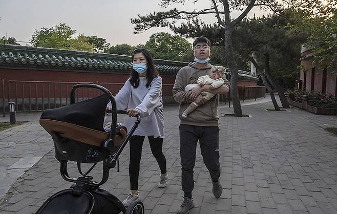 2021년 5월 중국 베이징의 한 공원에서 부부가 신생아를 데리고 걷고 있다. 게티이미지
