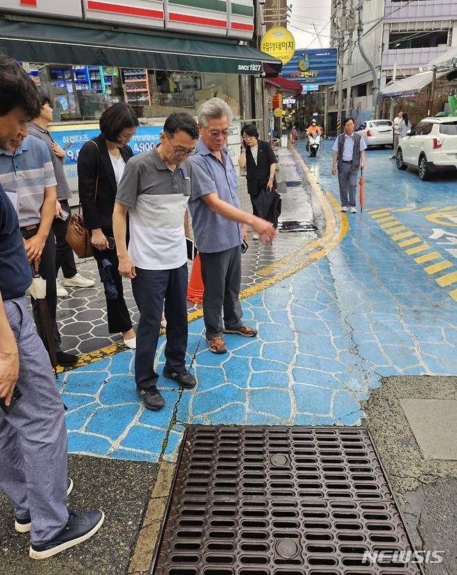 [거제=뉴시스]중소벤처기업부 손한국(오른쪽서 두 번째) 경남지방중소벤처기업청장이 9일 오후 거제 고현시장을 방문해 배수시설을 살펴보고 있다.(사진=경남중기청 제공)2024.07.09. photo@newsis.com