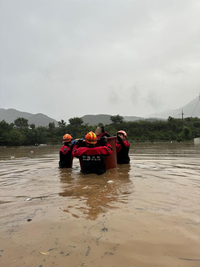 10일 오전 전북 완주군 운주면에서 소방관들이 밤사이 내린 폭우로 마을에 고립된 주민을 구조하고 있다. 전북소방본부 제공