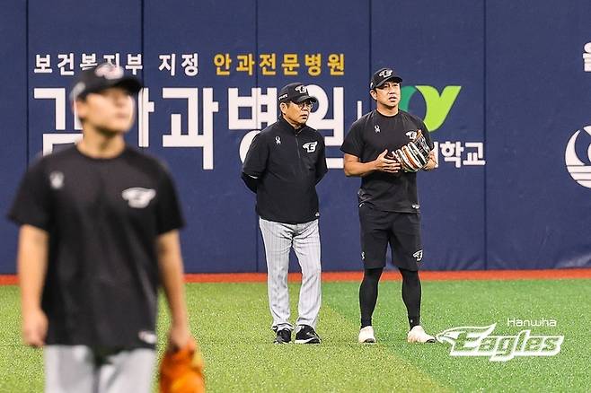 양상문 투수코치가 외야수 김강민과 대화하고 있다. 한화 제공