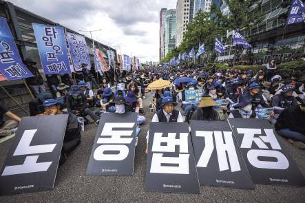 10일 서울 여의도 한국경제인협회 앞에서 열린 금속노조의 1차 총파업 대회에서 조합원들이 일명 노란봉투법(노조법 2,3조 개정) 개정과 타임오프 폐기 등의 내용을 담은 피켓을 들고 있다. [뉴시스]