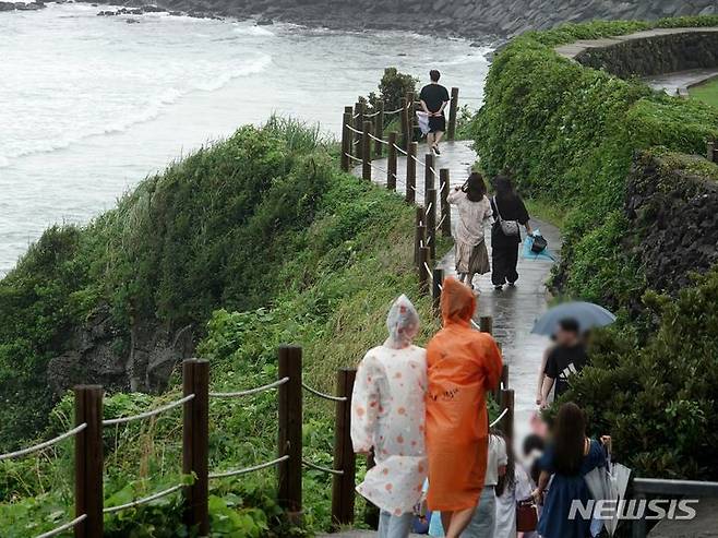 [제주=뉴시스] 오영재 기자 = 제주시 애월읍 한담공원에서 우비와 우산을 쓴 관광객들이 산책하고 있다. 2024.06.30. oyj4343@newsis.com