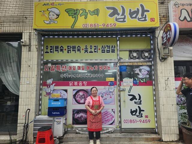 지난 9일 서울 금천구 독산동 택구네 집밥 앞에서 식당주인 이인숙씨가 사진촬영을 하고 있다