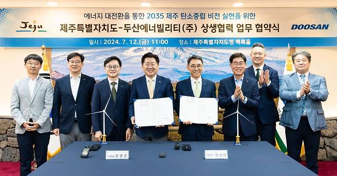 제주특별자치도 오영훈 도지사와 두산에너빌리티 정연인 부회장이 12일 제주도청 백록홀에서 ‘에너지 대전환을 통한 2035 제주 탄소중립 비전 실현에 관한 상생협력 업무협약(MOU)’을 체결하고 관계자들과 함께 기념촬영을 하고 있다. 사진=두산에너빌리티