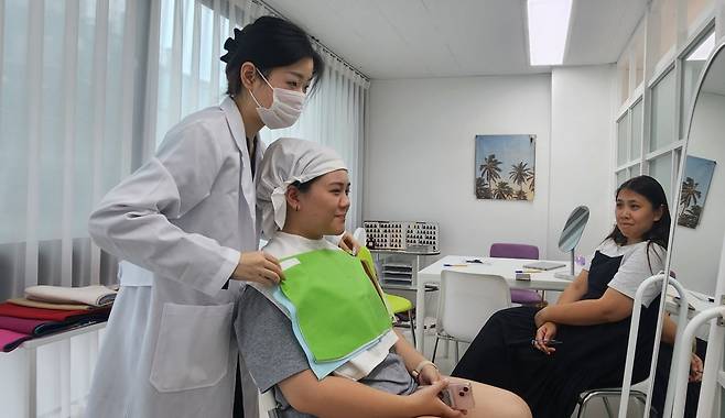 A personal color consultant conducts a color swatch test for a customer at Color Signal in Gangnam-gu, Seoul. (Choi Si-young/The Korea Herald)