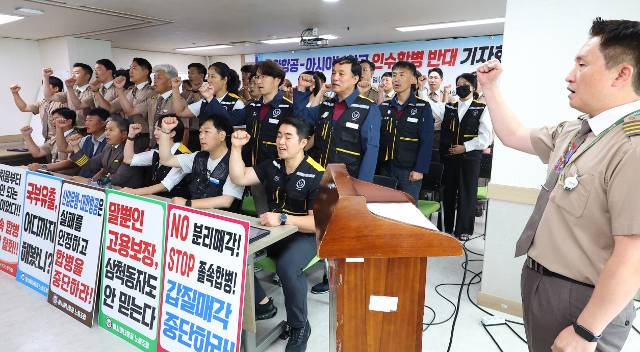 11일 오후 서울 중구 민주노총에서 열린 대한항공-아시아나항공 인수합병 반대 기자회견에서 아시아나항공노조원 및 아시아나항공조종사노조원들이 구호를 외치고 있다. 연합뉴스