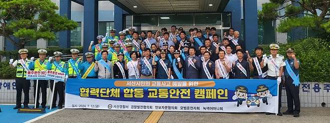 [서산=뉴시스] 충남 서산경찰서가 12일 시 전역에서 아침 출근 시간대 대대적인 교통사고 예방 캠페인을 벌인 가운데 이날 참여자들 중 일부가 본서 현관에서 화이팅을 외치며 기념 촬영을 하고 있다. (사진=서산경찰서 제공) 2024.07.12.  *재판매 및 DB 금지