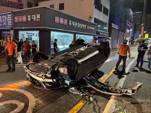 13일 오전 1시께 부산 해운대구 우동 해운대구청 어귀삼거리에서 구청 방향으로 달리던 벤츠 승용차가 가로등을 들이받고 뒤집혔다.(사진출처=해운대경찰서)