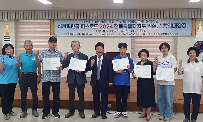 13일 전북 임실군 임실축협 대강당에서 열린 '신통일한국 피스로드 2024 임실군 통일대장정'에서 통일준비국민위원들에게 위촉장을 수여한 뒤 기념 촬영하고 있다.