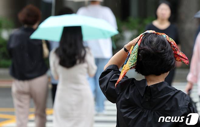 가을을 재촉하는 소나기가 내린 30일 서울 영등포구 여의도 일대에서 우산을 미처 챙기지 못한 시민들이 손수건으로 머리를 가린 채 발걸음을 재촉하고 있다. 2023.8.30/뉴스1 ⓒ News1 김성진 기자