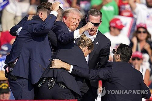 귀에 피묻은 상태로 급히 퇴장하는 트럼프 [버틀러 AP=연합뉴스]