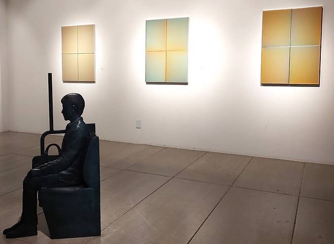 예화랑 2층 전시장. 윤종주 작가의 ‘시간을 품다’ 연작이 내걸린 벽면 앞 전시장에 이환권 작가의 납작한 인물 좌상이 놓였다. 노형석 기자
