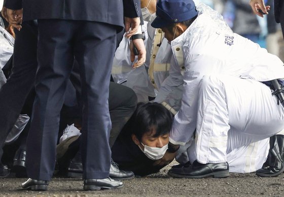 지난해 4월 기시다 후미오 일본 총리가 일본 와카야마(和歌山)현에서 현장 시찰을 마치고 연설을 시작하기 직전 폭발음을 야기시킨 물체를 던진 남성이 체포되고 있다. 연합뉴스