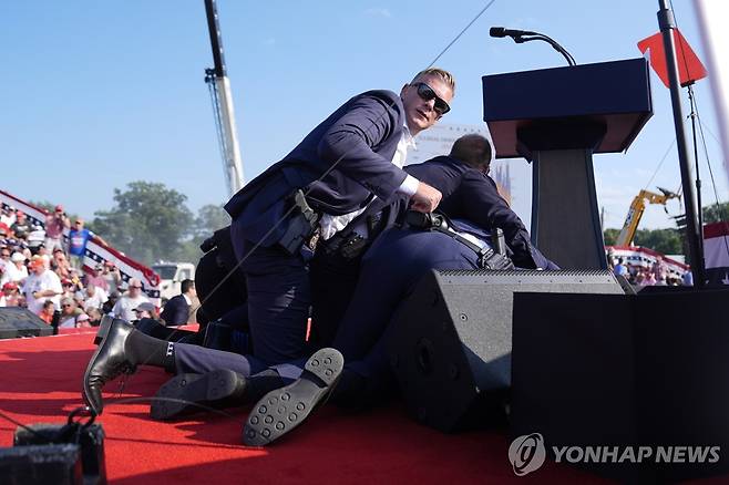 Election 2024 Trump Republican presidential candidate former President Donald Trump is covered by U.S. Secret Service agents at a campaign rally, Saturday, July 13, 2024, in Butler, Pa. (AP Photo/Evan Vucci)