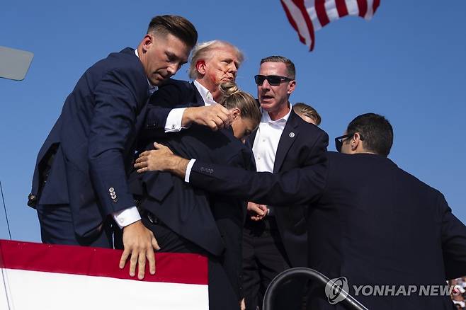 귀에 피묻은 상태로 급히 퇴장하는 트럼프  [AP=연합뉴스]