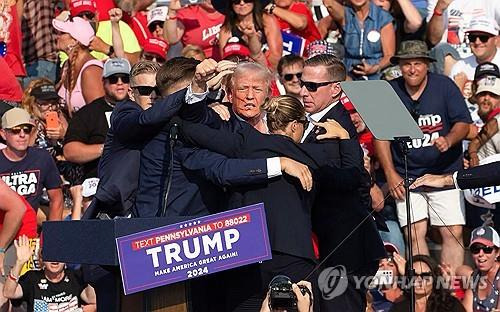 귀 윗부분 총격받아 피 흘리는 트럼프 [버틀러[미 펜실베이니아주] AFP=연합뉴스. 재판매 및 DB 금지]