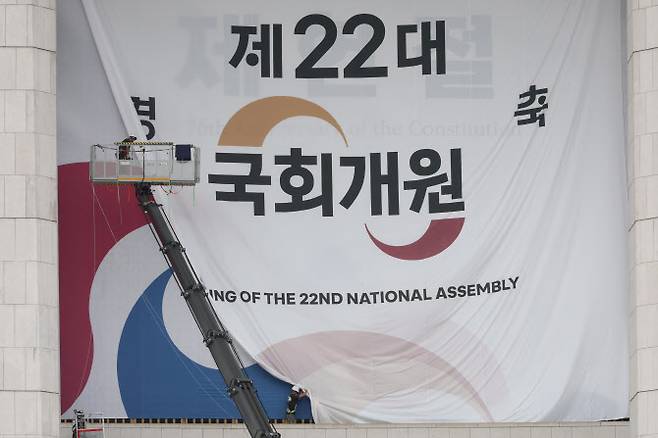 서울 여의도 국회의사당 본관에 설치된 제22대 국회 개원 현수막이 7일 오후 제76주년 제헌절을 알리는 현수막으로 교체되고 있다. 5일 열릴 예정됐던 22대 국회 개원식은 ‘채상병특검법’을 둘러싼 여야 충돌의 여파로 무기한 연기됐다.(사진=연합뉴스)