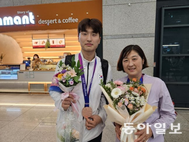지난해 항정우 아시아경기에서 은메달을 딴 아들 김원호와 함께 공항에서 사진을 찍은 길영아 감독. 동아일보 DB