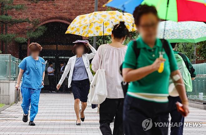 갑자기 내리는 소나기 (서울=연합뉴스) 서대연 기자 = 10일 오후 서울 종로구 서울대병원에서 의료관계자들이 갑자기 내린 소나기에 서류나 손으로 머리를 가린 채 급하게 이동하고 있다. 2024.7.10 dwise@yna.co.kr