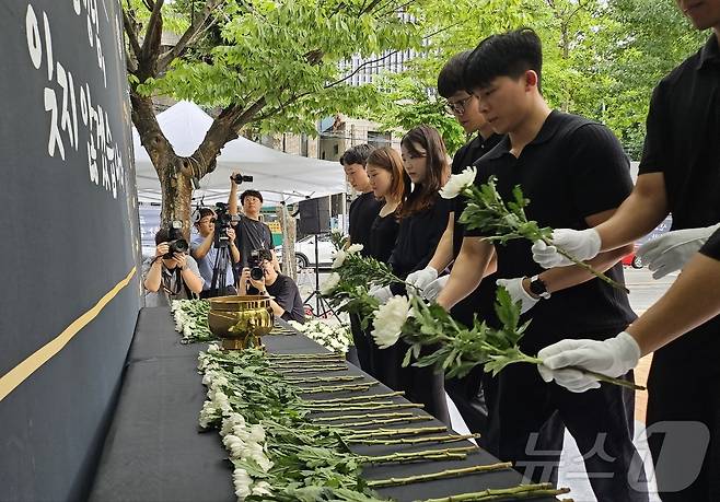 서울 서이초등학교 교사 사망 사건 1주기를 하루 앞둔 17일 대구교육청 분수광장에서 진행된 추모제에서 대구교총 청년위원회원와 동료 교사 등이 고인을 애도하며 헌화하고 있다. 2024.7.17/뉴스1 ⓒ News1 남승렬 기자