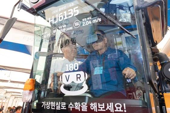 지난해 10월 전북 익산시 익산농수산물도매시장에서 열린 '2023 익산농기계박람회'를 찾은 관람객이 VR을 착용하고 콤바인을 조작하고 있다. [사진 익산시]