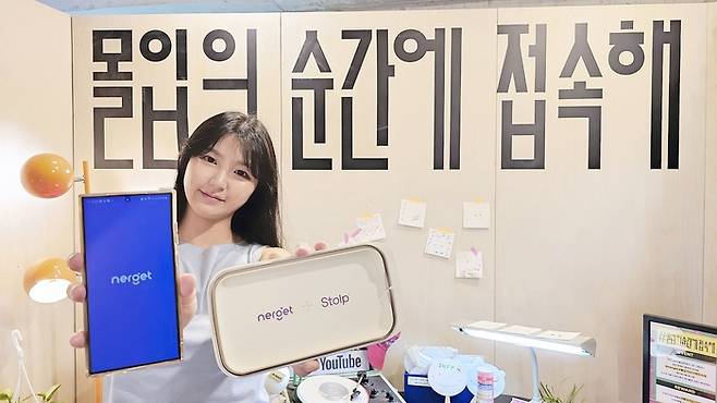 LG유플러스 직원이 팝업 부스에서 ‘몰입의 순간에 접속해’ 캠페인 이벤트로 제공하는 ‘스톨프 폰 박스’를 소개하고 있다. LG유플러스 제공