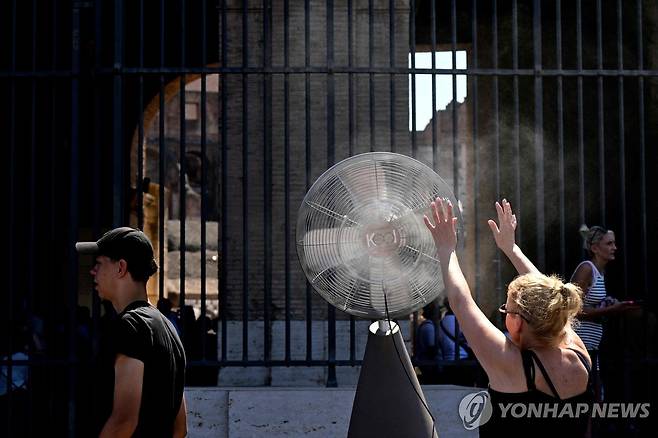 더위 식히는 이탈리아 관광객 (로마 AFP=연합뉴스) 11일(현지시간) 이탈리아 로마의 관광객이 야외 선풍기 앞에서 더위를 식히고 있다. 2024.07.17