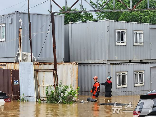 경기북부 지역에 호우 특보가 내려진 18일 경기 파주시 월롱면의 한 공장이 침수돼 소방대원이 고립된 근로자를 구조하고 있다. (경기북부소방재난본부 제공) 2024.7.18/뉴스1