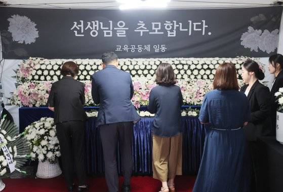 서이초 교사 사망 1주기를 하루 앞둔 17일 오전 종로구 서울시교육청에 마련된 추모 공간에서 추모객들이 헌화하고 있다. 연합뉴스