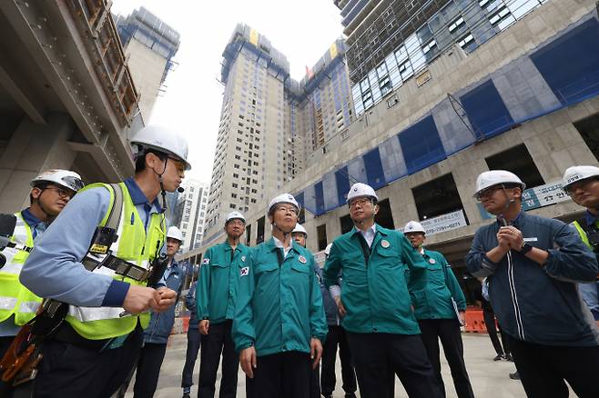 건설업체와 정부부처가 장마철 현장 관리에 돌입했다. 사진은 박상우(앞줄 오른쪽 두번째) 국토부 장관과 이정식(앞줄 왼쪽 두번째) 고용부 장관이 지난 12일 장마철 대비 상황 점검을 위해 서울 강동구 천호동 공동주택 재건축 정비사업 현장을 찾아 점검에 나섰던  모습. /사진=공동취재단(뉴시스)