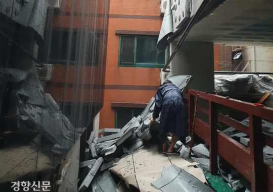 An employee of a management company cleans up finishing materials fallen during the collapse of an outer wall, which collapsed on July 18, at an apartment building in Michuhol-gu, Incheon. Reporter Lee Ye-seul