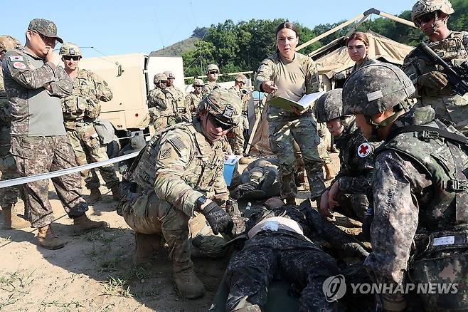 함께 부상병 치료하는 한미 육군 2024년 6월 26일 강원 철원군 심일훈련장에서 열린 한미연합군사령부·합동참모본부·주한미군사령부 연합 의무지원 야외기동훈련(FTX)에서 육군 6사단 및 미 2사단, 한미연합사단 의무요원들이 부상자 응급처치를 실시하고 있다. [연합뉴스 자료사진. 재판매 및 DB 금지]