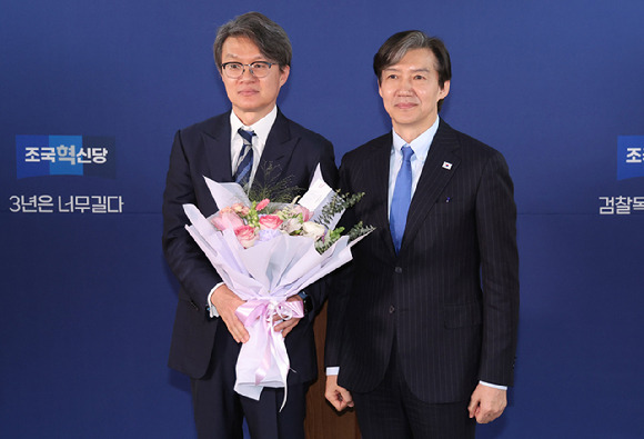 조국 조국혁신당 대표가 11일 오전 서울 여의도 조국혁신당 당사에서 열린 전문가 입당식에서 정상진 영화수입배급사협회장에게 꽃다발을 전달한 후 기념촬영을 하고 있다. 2024.03.11. [사진=뉴시스]