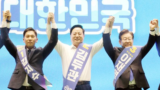 더불어민주당 새 지도부 선출을 위한 전당대회를 앞두고 20일 제주시 한라체육관에서 열린 합동연설회에서 김지수, 김두관, 이재명 대표 후보(왼쪽부터)가 손을 맞잡고 포토타임을 갖고 있다. 연합뉴스