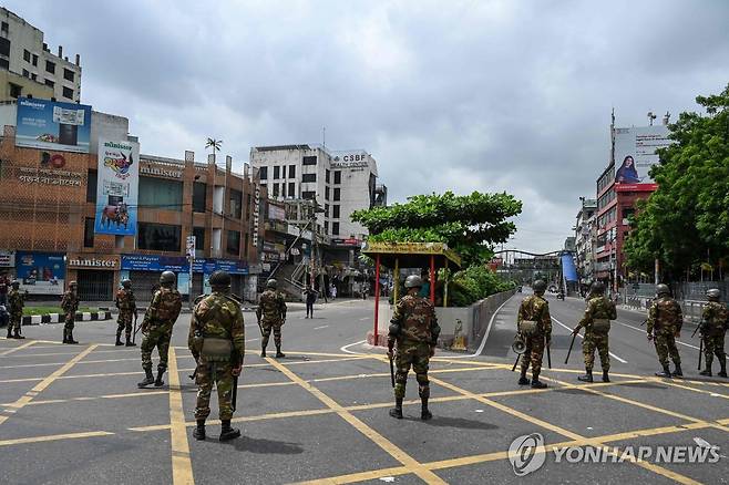 통행 금지하는 방글라데시군 (다카 AFP=연합뉴스) 20일(현지시간) 방글라데시 전역에서 통행금지령이 내려지자 방글라데시군이 수도 다카에서 도로를 따라 경계를 서고 있다. 2024.7.20. photo@yna.co.kr