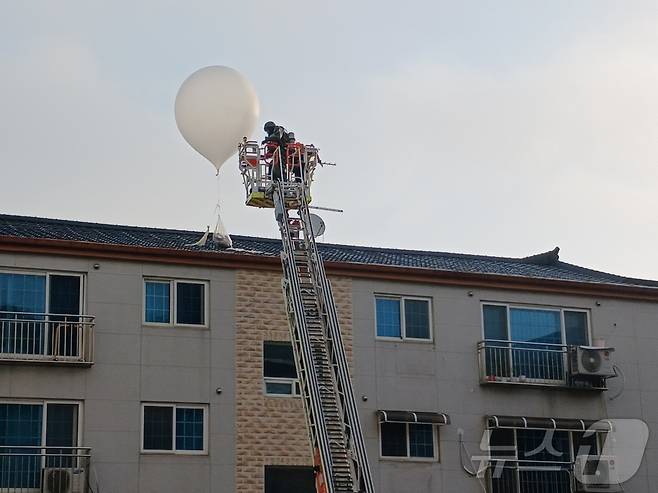 9일 오전 5시 32분쯤 인천 미추홀구 학익동 한 빌라 옥상에 떨어진 오물풍선을 소방대원이 치우고 있다.(인천소방본부 제공)2024.6.9/뉴스1 ⓒ News1 박소영 기자