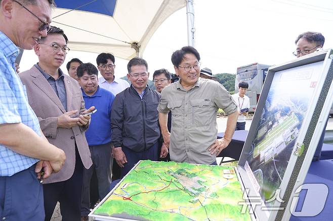 강기정 광주시장이 21일 대구 군위군 소보면 대구경북 통합신공항 부지를 찾아 김진열 군위군수, 대구시 관계자 등과 조감도를 보며 건립 현황을 살펴보고 있다.(광주시 제공)2024.7.21/뉴스1