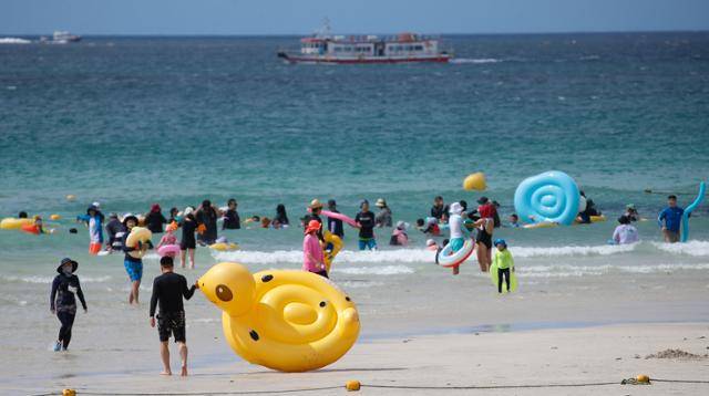 폭염특보가 발효 중인 지난 21일 오후 제주시 협재해수욕장을 찾은 관광객들이 시원한 바닷물에 몸을 담그며 즐거운 시간을 보내고 있다. 뉴시스